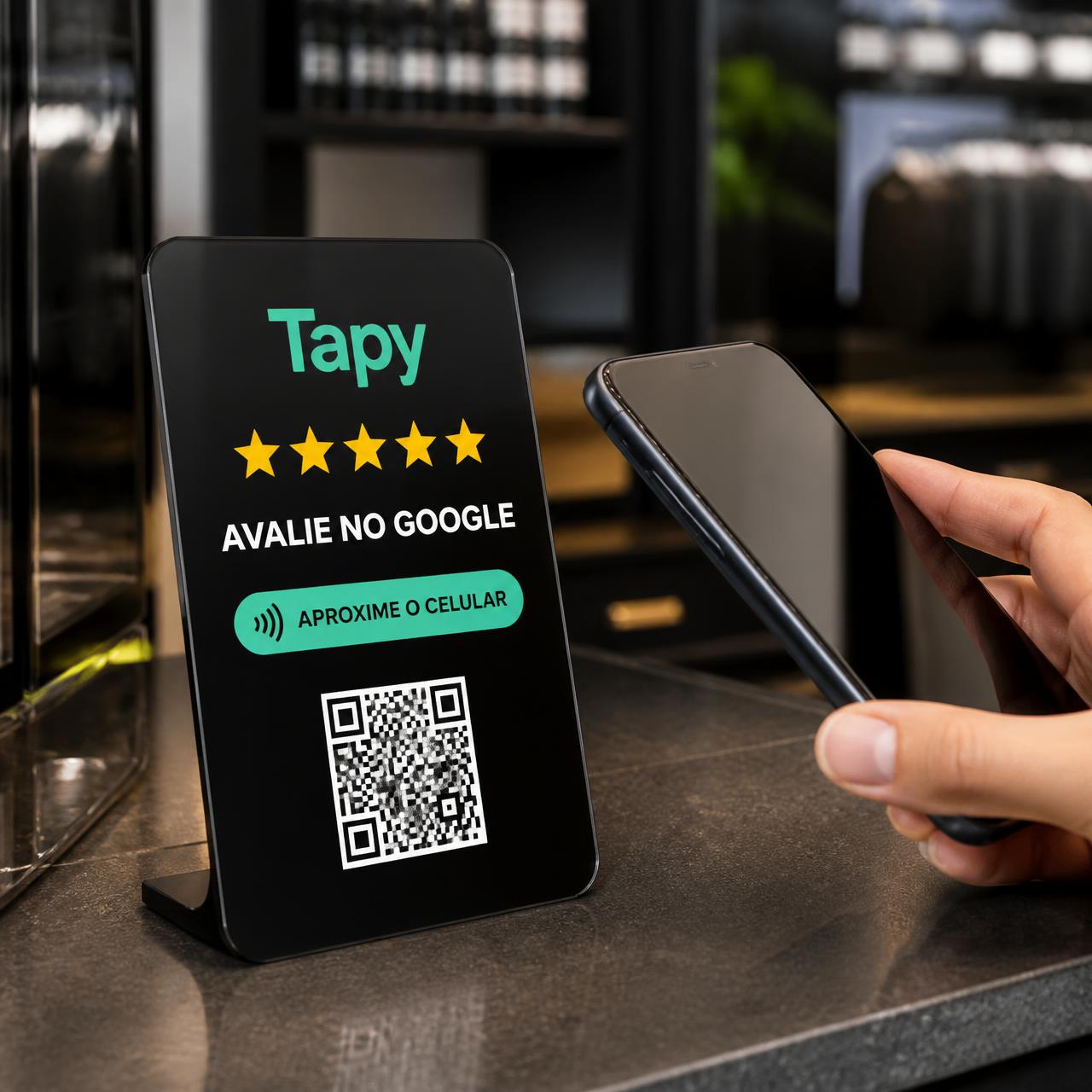 Plaquinha NFC Tapy em cima de um balcão moderno, ao lado de um smartphone